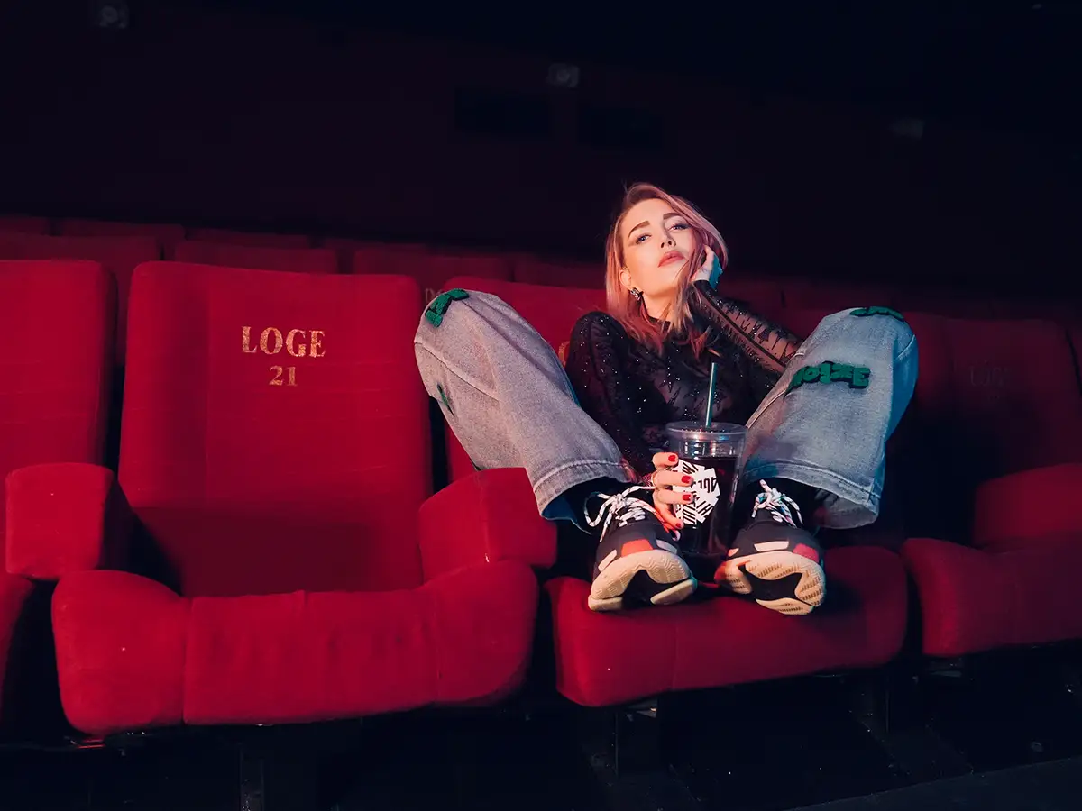Alexa Feser sitzt auf einem roten Kinosessel