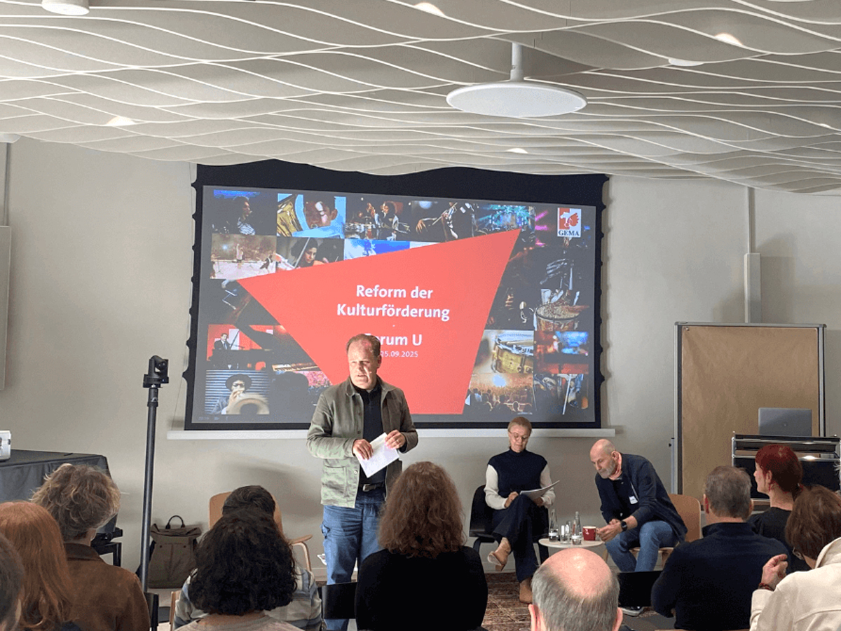 Musikschaffende bei Vortrag in großem Raum