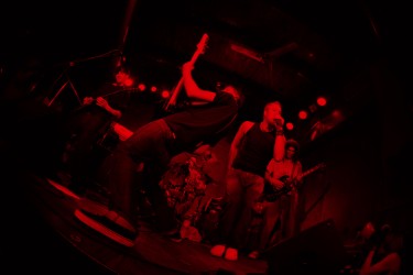 Eine Band in rot beleuchteter Umgebung.