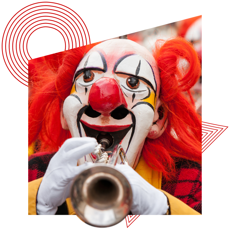 Clown mit roter Perücke und weißem Gesichtsschmuck spielt Trompete