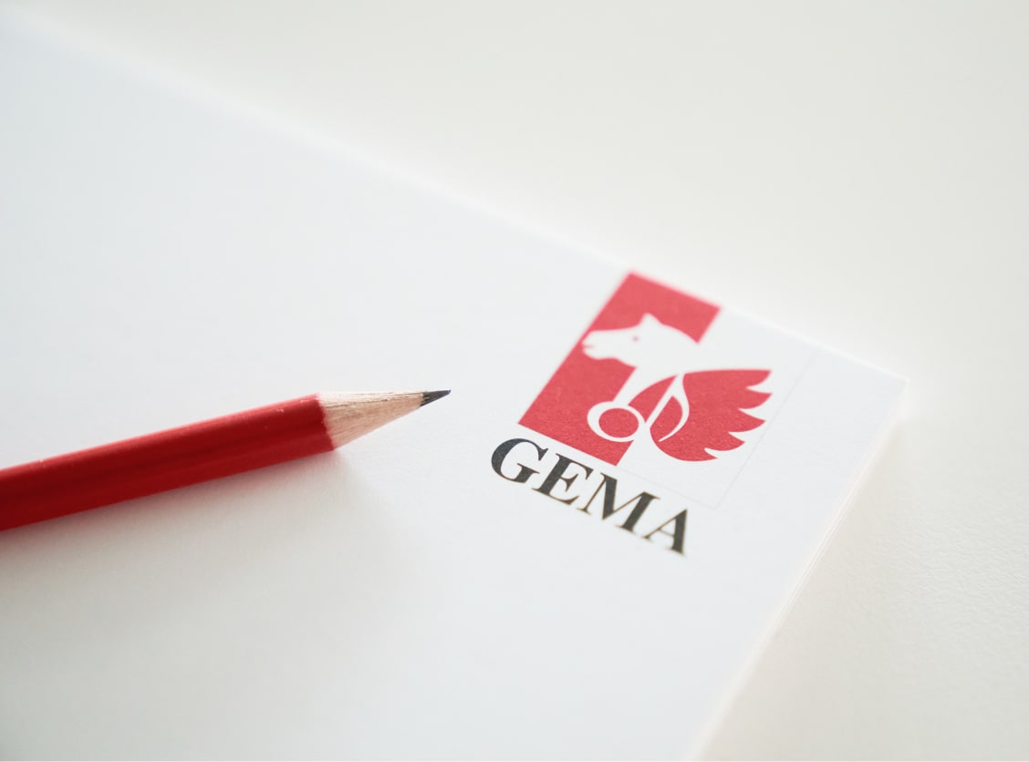 Red pencil on paper with red Gema logo.
