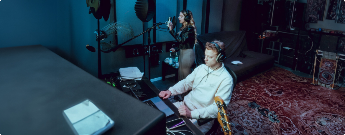 Eine Frau und ein Mann nehmen Musik im Studio auf.