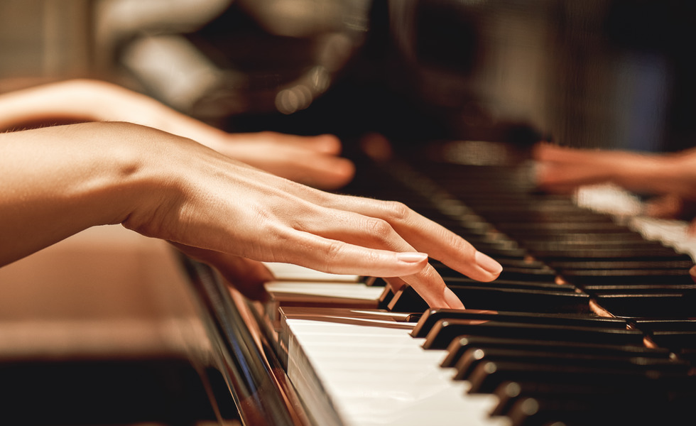 Hände spielen auf einem Klavier.