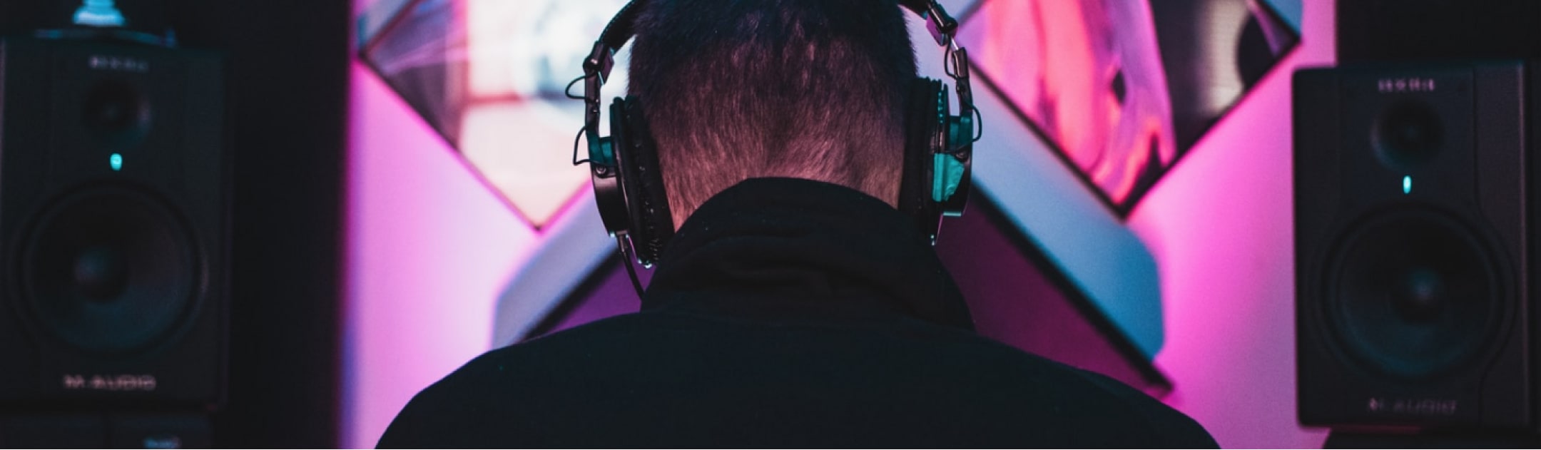 MusicHub DJ sitzt an seinem Arbeitsplatz mit Kopfhörern