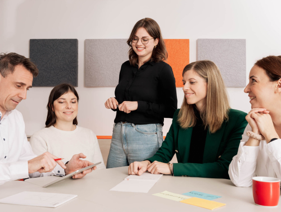 Required image descriptionGruppe von Kollegen schaut in Tablet